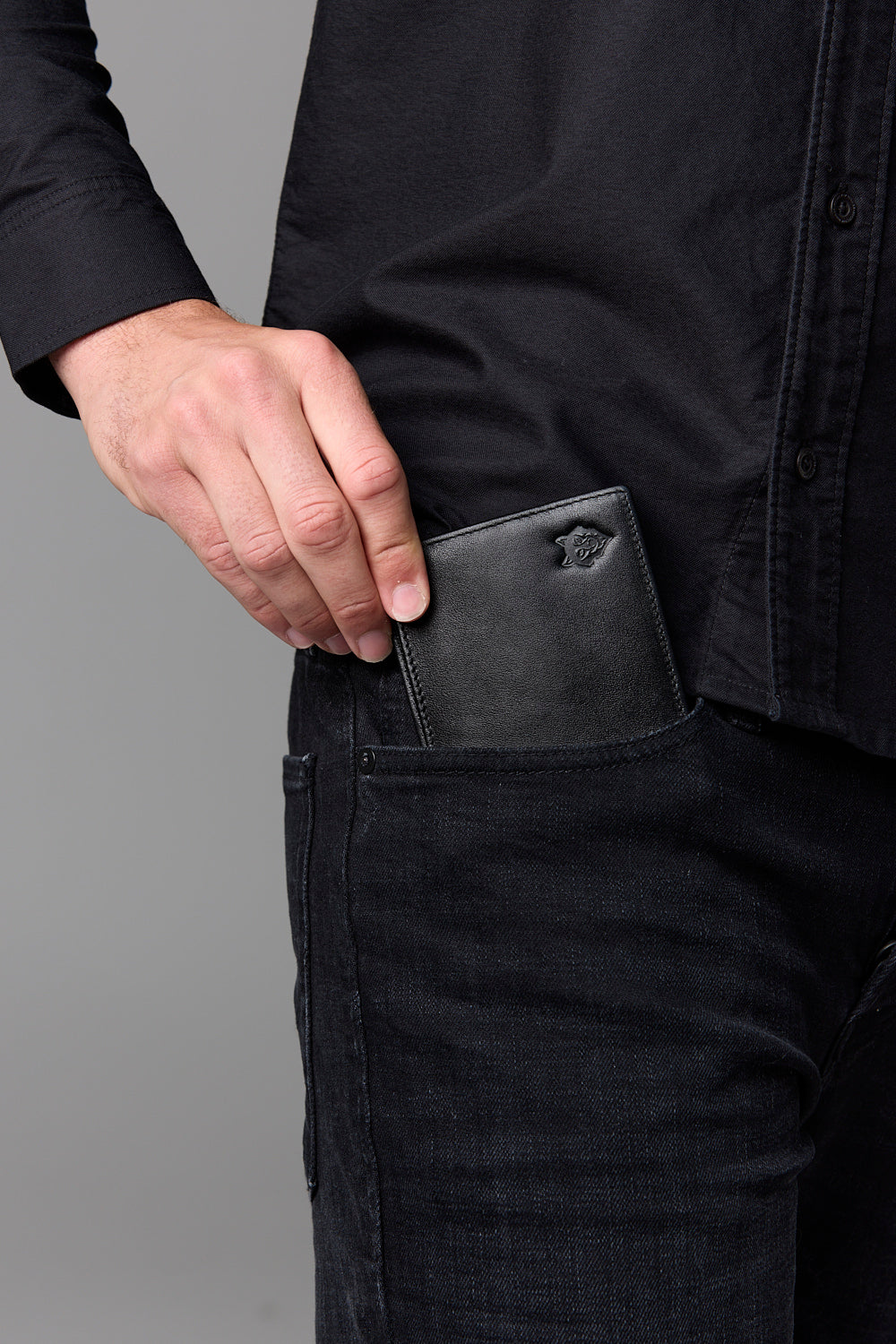 Man in black shirt and jeans with wallet in pocket